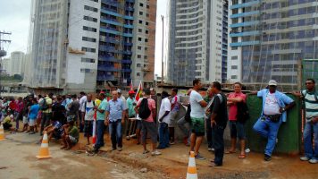 Fila de trabalhadores da construção civil em frente a canteiro de obras, na Bahia: retrato do setor