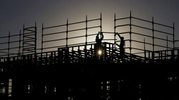 Construção civíl Trabalhadores constroem andaimes em um canteiro de obras no subúrbio de Greenhills Beach, em Sydney, na Austrália. Foto: Jason Reed / Reuters